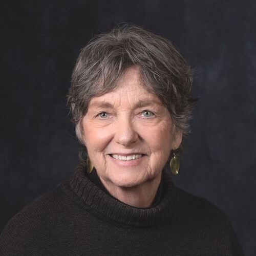 Deborah Penrose smiling in a professional headshot, wearing a dark turtleneck sweater