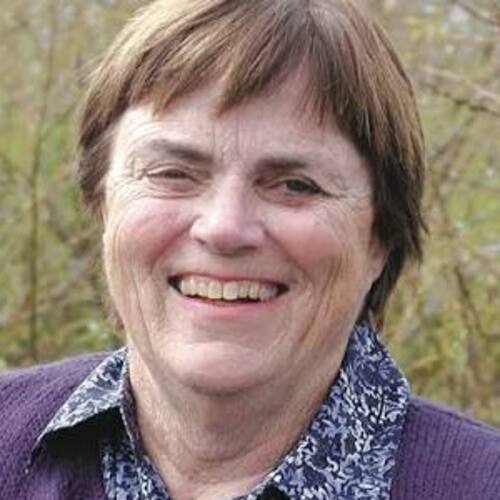 Lennie Roberts smiling outdoors, wearing a purple cardigan